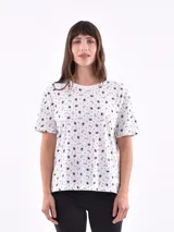 Remera blanca de manga corta con estampado de ojos, pestañas y rayos en color negro.