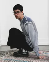 Sweater de tejido de punto de algodón con cuello redondo, diseño de manga larga y efecto desteñido en tonos azul índigo y blanco.