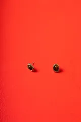Aros tipo caravanas con diseño orgánico de bordes irregulares en tono dorado, con centro de piedra pulida en color marrón oscuro.