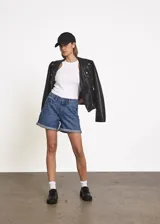 Short de denim azul medio, corte mom fit, con dobladillo revuelto en las piernas, tiro medio y bolsillos clásicos.