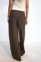 Pantalón fluido de tiro alto con diseño de rayas diplomáticas, color marrón, con pliegues en el delantero, bolsillos laterales y silueta amplia.