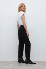 Pantalón chino de corte recto y tiro medio, color negro, con bolsillos laterales y cierre frontal con botón y cremallera.