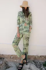 Pantalón de lino y algodón con estampado de paisajes en tonos verdes y grises. Tiene corte recto, cintura elastizada, bolsillos laterales y pequeños cortes en el ruedo.