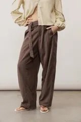 Pantalón de corte ancho y holgado, de color negro, con diseño estructurado y cinturón ajustable integrado en la cintura.