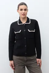 Chaqueta tejida de punto color naranja, con cuello camisero, cierre frontal de botones y dos bolsillos frontales con solapa. Presenta detalles de bordado en contraste en el cuello y los bolsillos.