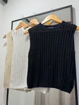 Chaleco de punto calado color negro, con cuello redondo y sin mangas.