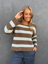 Sweater de punto a rayas horizontales en color marrón y celeste, con cuello redondo a la base y mangas largas.