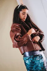 Campera de cuero oversize con solapa amplia de corderito, mangas anchas y detalle de cuero trenzado en la parte delantera.