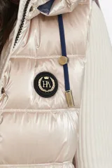 Chaleco largo azul con capucha desmontable, cierre central con cremallera de doble carro y bolsillos con tapa. Diseño acolchado a rayas horizontales. Largo 86cm.