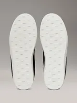 Zapatillas urbanas Calvin Klein Jeans de ante negro con logo CK grabado en el lateral, detalle de talón en gris, cordones grises y suela cupsole blanca.