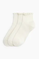 Pack de tres medias tobilleras de punto acanalado en color blanco, con borde superior elástico con volados.