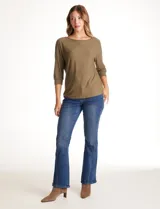 Blusa de tejido acanalado con cuello redondo y mangas tres cuartos. Presenta detalle de tachas metálicas a lo largo de los hombros y mangas, con puños elastizados.