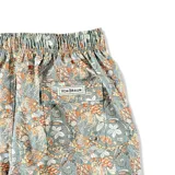 Short de baño con estampado floral y paisley en tonos azules, naranjas y blancos. Cuenta con cintura elástica con cordón ajustable, bolsillos laterales y bolsillo trasero.