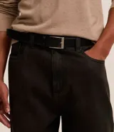 Cinturón de cuero negro liso con hebilla metálica plateada de forma rectangular.