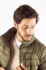 Campera puffer de diseño acolchado en color azul oscuro, con cuello elevado, cierre frontal completo y bolsillos laterales con cierre. Incluye un bolsillo adicional en el pecho y capucha oculta.