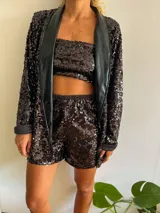 Blazer negro con lentejuelas y solapa de cuero sintético.