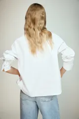 Camisa de manga larga en tejido de popelín, con cuello solapa y cierre frontal con botones ocultos por tapeta.