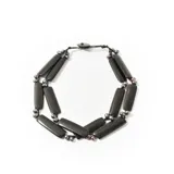 Collar de dos hilos de cuentas negras en forma de tubo, con cuentas pequeñas de perlas iridiscentes y cierre de botón.