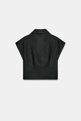 Camisa color crudo confeccionada con lino, de corte holgado, cuello solapa y escote en V. Tiene manga sisa y detalle de pliegue en el delantero. Cierre frontal con botón.