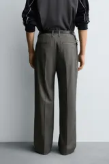 Pantalón de vestir con corte flare y ajuste relajado, confeccionado en tejido con viscosa y patrón de espiga. Cuenta con bolsillos frontales, bolsillos traseros de vivo y cierre frontal con cremallera y botón.