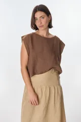 Blusa sin mangas color marrón oscuro, con escote redondo y corte holgado. El tejido parece ser lino o una mezcla con textura visible.