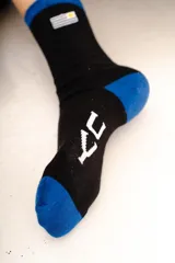 Medias de algodón color crema con detalle de franja gris en el puño y bordado de la bandera de Uruguay en el lateral.