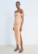 Vestido midi de algodón color durazno, con escote palabra de honor y mangas cortas abullonadas caídas. Presenta un diseño entallado con abertura lateral en la falda y cierre de cremallera lateral.