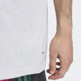 Remera de algodón color gris jaspeado, con cuello redondo y corte holgado. Presenta un estampado gráfico en el frente que combina el logo de Adidas con un personaje animado.