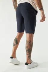 Bermuda tipo chino color verde oliva, con corte clásico, bolsillos laterales y traseros, cierre frontal y pasacintos.