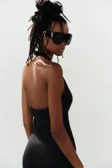 Mono de poliamida color negro con escote halter y escote en V profundo, de corte ajustado y largo por encima de la rodilla.