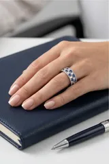 Anillo de plata 925 con diseño de banda ancha, decorado con una hilera central de circonias blancas en corte baguette y dos hileras laterales de circonias azules redondas.