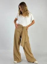 Pantalón de lino color beige, de corte palazzo y tiro alto, con lazo para atar en la cintura.