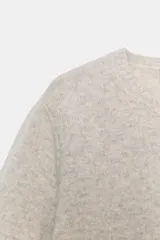 Jersey de punto color beige, confeccionado en lana 100%, con cuello redondo y manga corta.