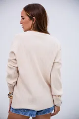 Sweater de tejido de punto acanalado en color crudo, con cuello redondo y mangas largas con puños ajustados.