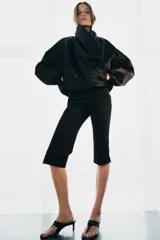 Chaqueta bomber negra ZW Collection con acolchado interior, cuello envolvente de solapa cruzada, mangas largas con puños elásticos y bajo con elástico.