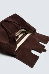 Bolso de mano marrón oscuro de cuero gamuzado, con cierre de solapa imantada y doble asa corta.