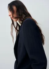 Blazer de corte recto y diseño de raya diplomática, con cuello de solapa con muesca, cierre frontal de doble botonadura y mangas largas con puños abotonados. Cuenta con forro interior y dos bolsillos de solapa en la parte frontal.