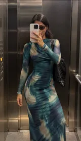 Vestido midi de manga larga con estampado tie-dye en tonos azul, celeste y beige, confeccionado en tela elastizada y diseño ajustado.