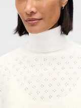Buzo polera de punto con diseño calado pointelle, de corte holgado, cuello alto y mangas largas con puños acanalados.