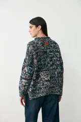 Sweater de punto con diseño multicolor en tonos azules, con cuello redondo y corte holgado de manga larga.