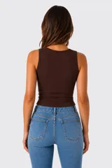 Top sin mangas al cuerpo, de color blanco, confeccionado en tejido acanalado, con diseño cut-out frontal en el escote.