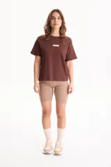 Remera de algodón amarilla de manga corta, con corte suelto y pequeño aplique rectangular en el pecho.