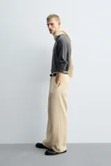 Pantalón de corte wide fit confeccionado en pana de algodón color marrón oscuro. Presenta bolsillos frontales, bolsillos traseros de vivo con botón y cierre frontal con cremallera y botón.