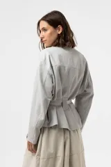 Chaqueta de calce relajado y estilo utilitario, color gris, con bolsillos delanteros grandes con solapa y cinturón ajustable en la cintura.