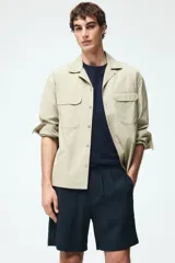 Pantalon corto de corte relajado color azul marino, confeccionado en tejido texturizado suave de mezcla de viscosa. Cuenta con cierre decorativo, cintura con elástico revestido y cordón de ajuste, bolsillos laterales discretos y bolsillo trasero insertado.