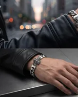 Pulsera de eslabones gruesos de acero con dije central en forma de cruz con detalles grabados.