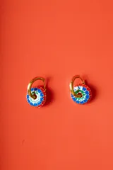 Aros tipo argolla dorados con dije circular esmaltado en colores rojo, azul, verde y blanco, con un patrón floral.