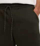 Bermuda masculina de algodón con felpa, color negro, corte slim fit. Presenta cintura elástica con cordón ajustable, bolsillos y etiqueta aplicada.