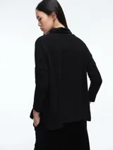 Buzo tejido de cuello alto, con diseño de sisa caída y silueta holgada. Presenta aberturas laterales en el ruedo que aportan movimiento.