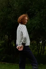 Cardigan reversible de punto con estampado de rombos pequeños, cuello alto y cierre frontal completo con botones. Presenta detalles de ribetes en color contrastante en cuello, puños y cartera de botones.